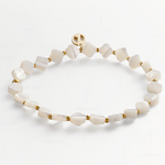 A beaded stretch bracelet featuring irregular white mother-of-pearl beads and small gold spacer beads, with a gold clasp, displayed on a clean white background.