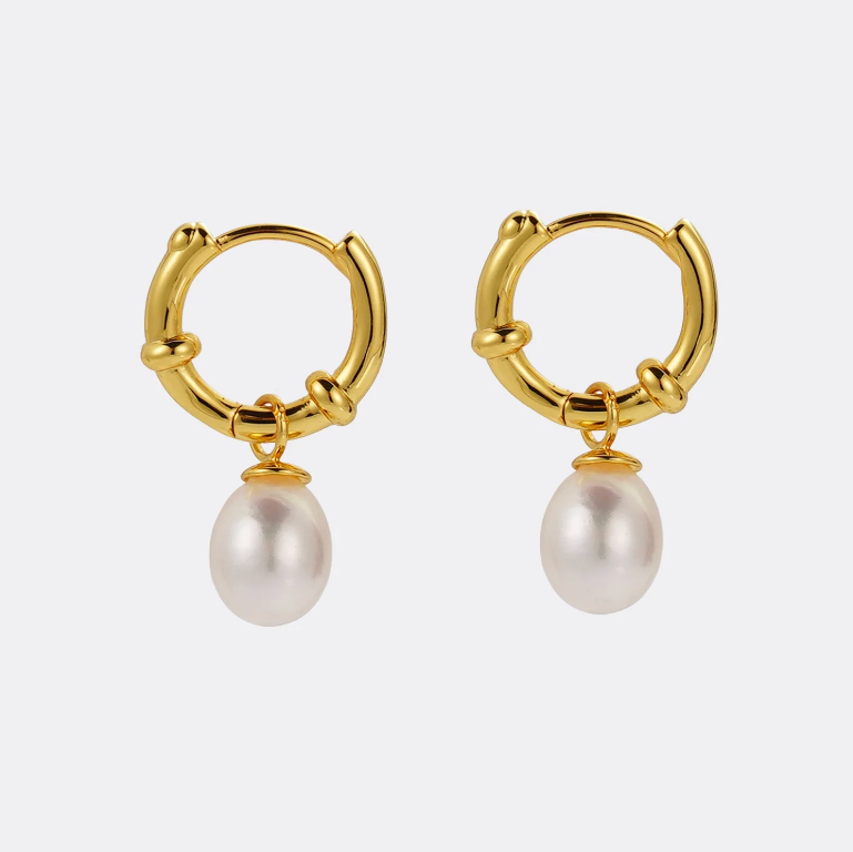 Gold hoop earrings with pearl drops on a white background