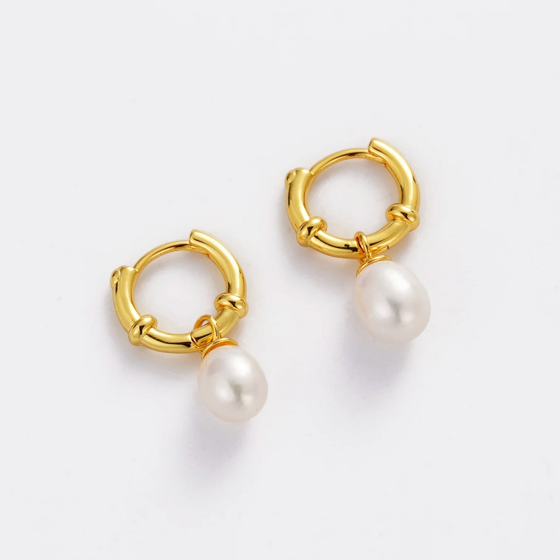 Gold hoop earrings with pearl drops on a white background