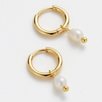 Gold hoop earrings with pearls on a white background