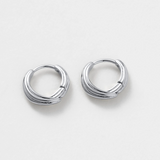 Pair of silver hoop earrings on a light gray background