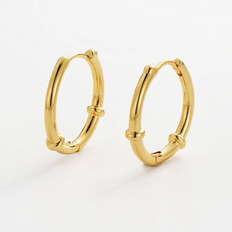 Gold hoop earrings on a light gray background
