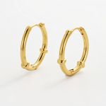 Gold hoop earrings on a light gray background