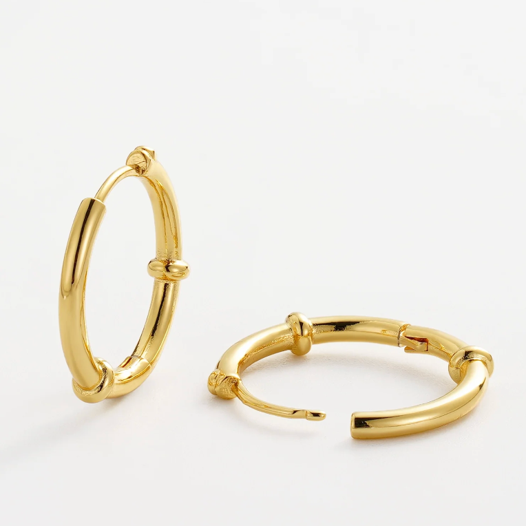 Gold hoop earrings on a light gray background