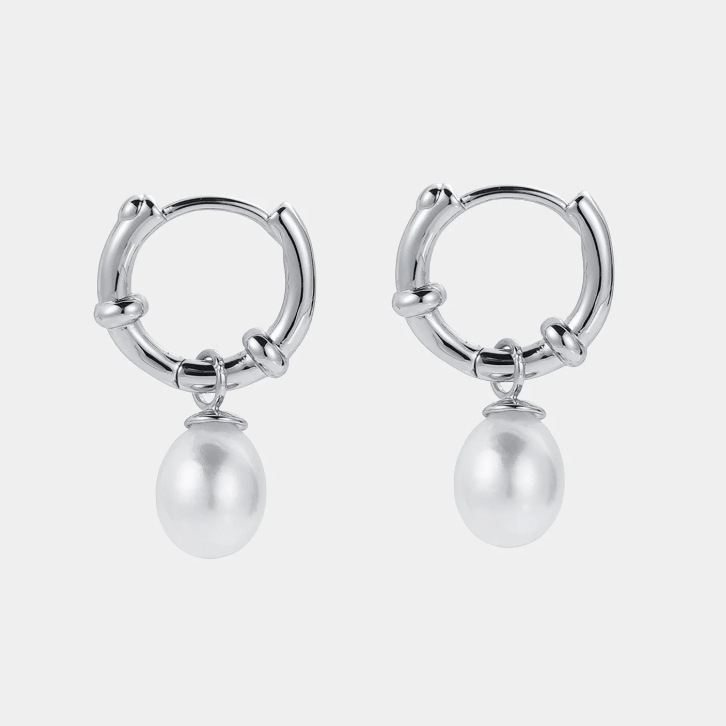 Silver hoop earrings with pearl drops on a white background