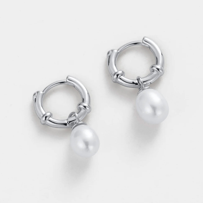 Silver hoop earrings with pearl charms on a light gray background